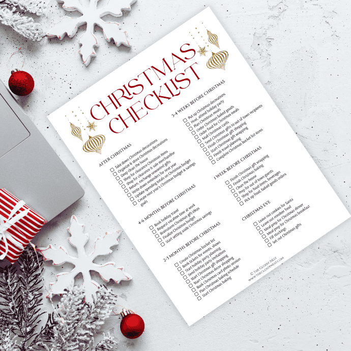 A Christmas checklist on a table with festive decor, including red ornaments, pine branches, and a wrapped gift. The checklist is divided into sections for tasks to complete before and after Christmas.